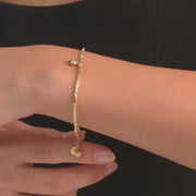 Woman wearing the 14ct gold heart charm bracelet, showcasing its elegant design