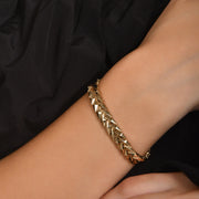 14ct gold geometric link bracelet with polished finish and secure clasp, hallmarked by the Edinburgh Assay Office worn by a model