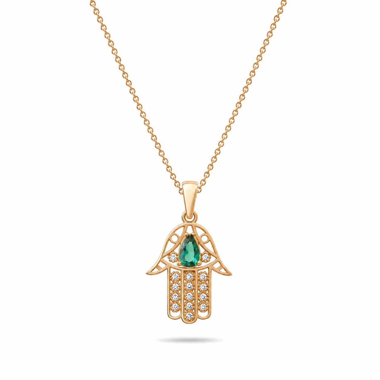 Gold Hamsa hand pendant with a green gemstone on a white background
