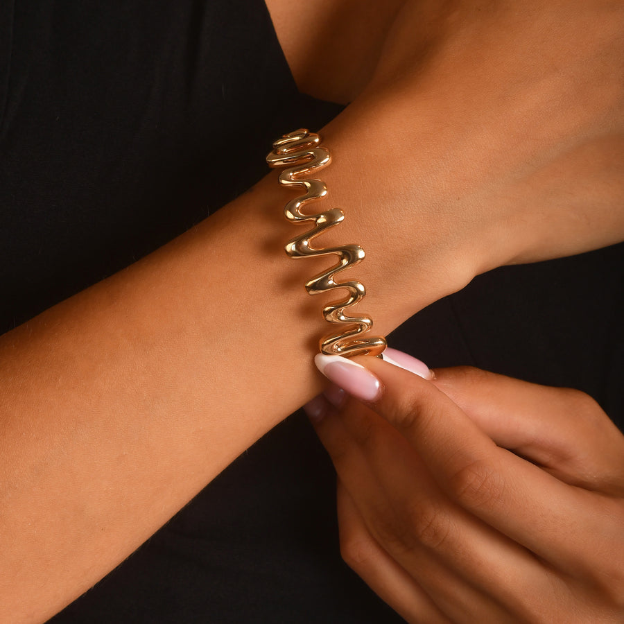 Woman wearing hallmarked 14ct solid gold zigzag bangle on wrist