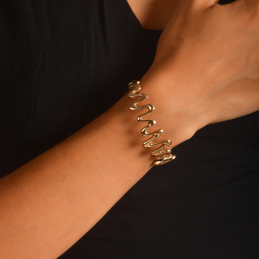 Woman wearing hallmarked 14ct solid gold zigzag bangle on wrist