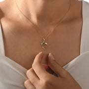 Elegant dolphin pendant in 14ct gold, perfect for women and teens, shown on a neckline.