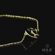 Charming 9ct gold bracelet featuring a linked heart centerpiece, embodying a delicate expression of love, displayed on a slender gold chain against a white backdrop, part of Kolié's romantic jewelry line