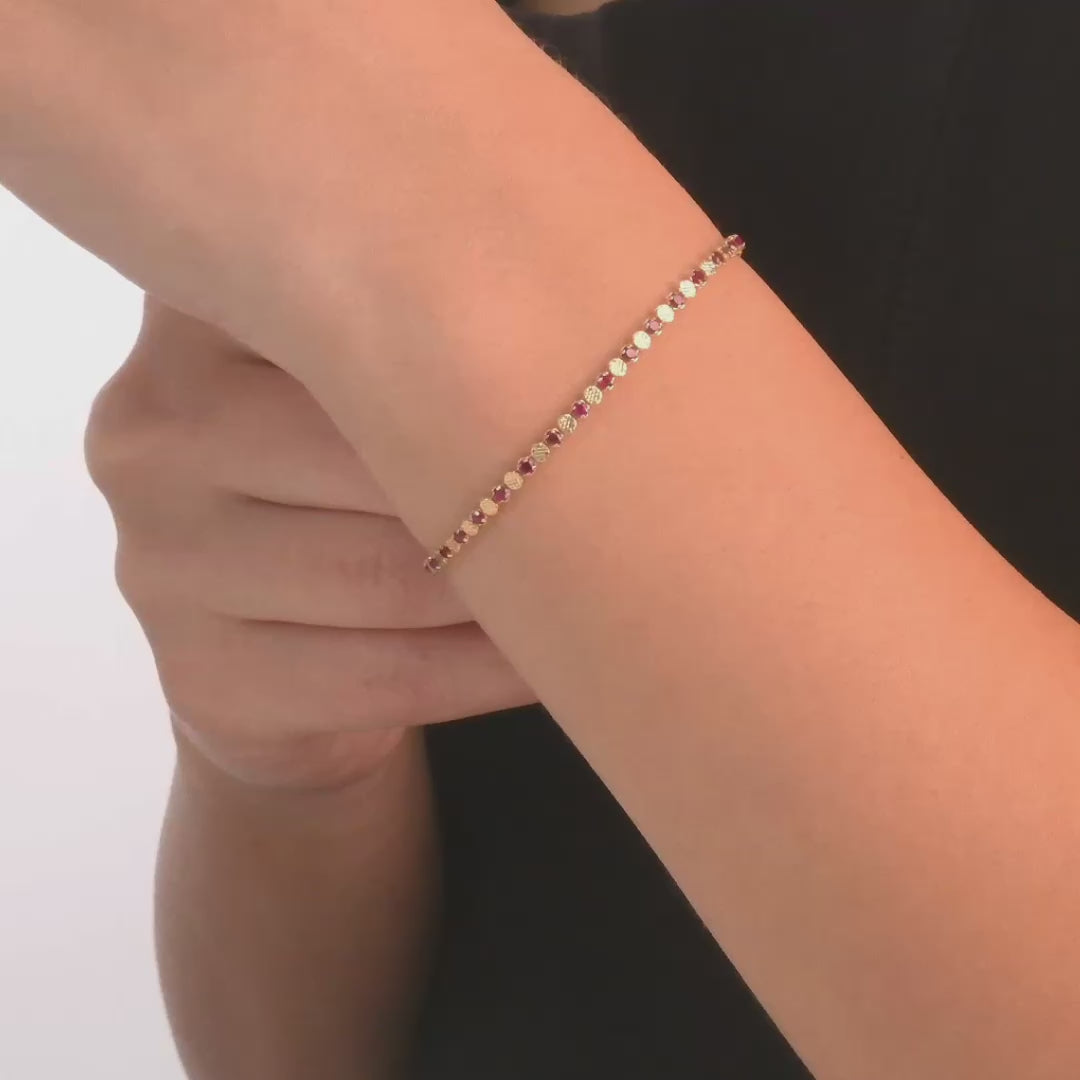 Woman wearing the 14ct gold bracelet with red cubic zirconia, showcasing its bold and elegant design.