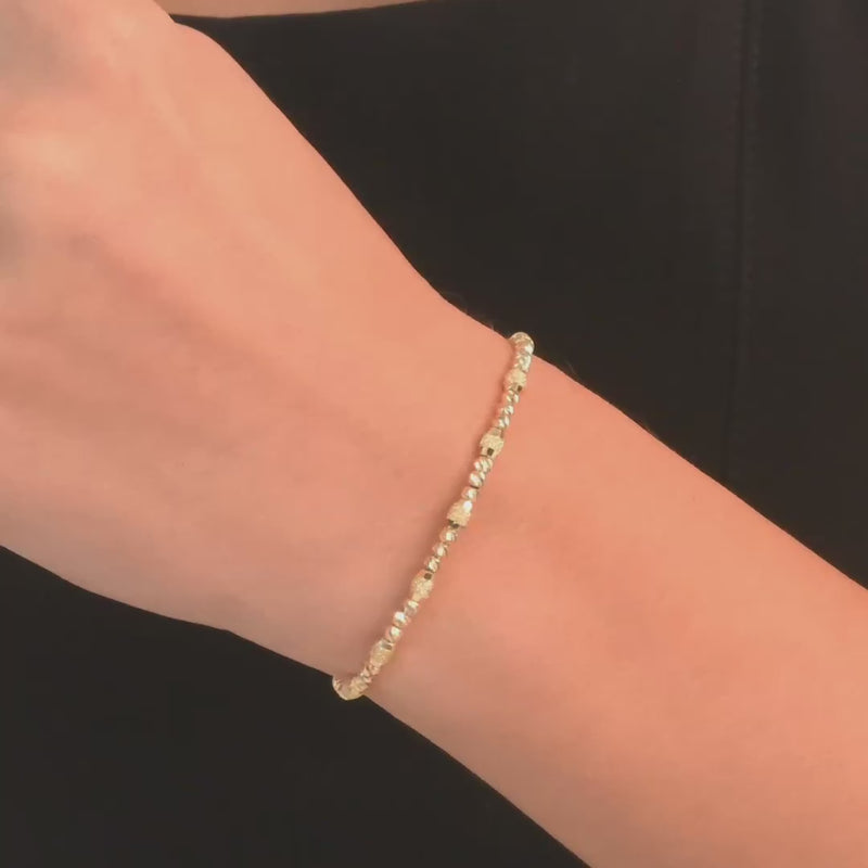 The bracelet worn on a woman's wrist, highlighting its elegant and delicate beaded design.