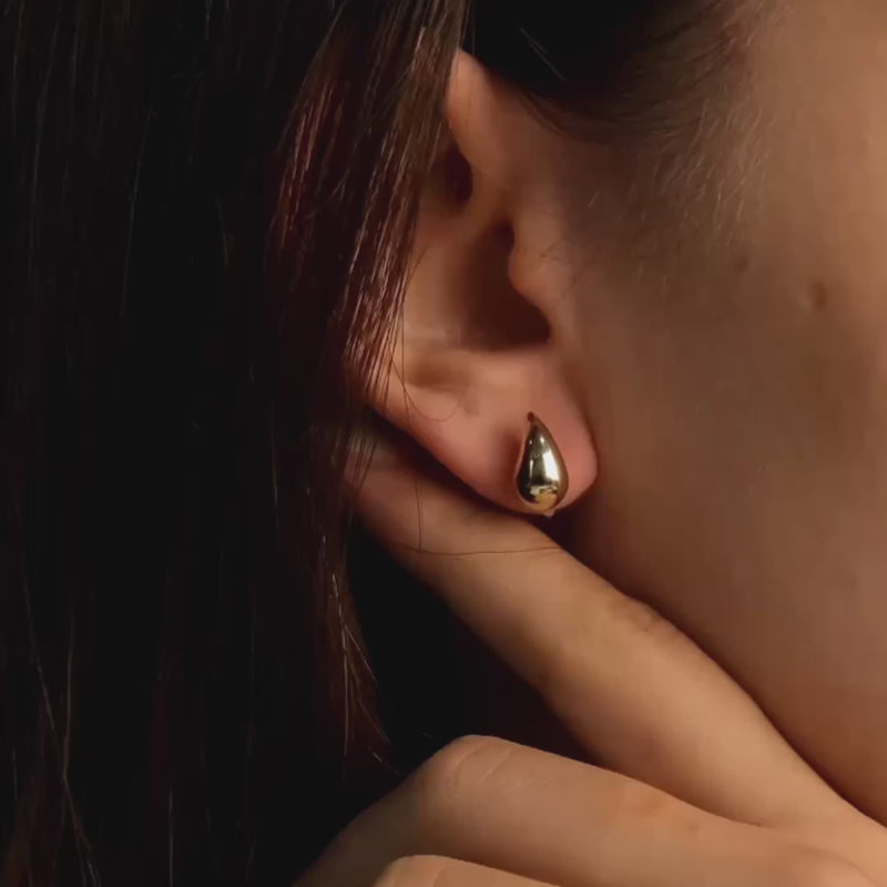 View of 14ct gold teardrop earrings worn by a woman, highlighting the elegant drop shape