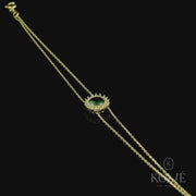 Sophisticated Kolié 9ct yellow gold bracelet with a vibrant green cubic zirconia, encircled by a halo of sparkling stones set in a refined chain.