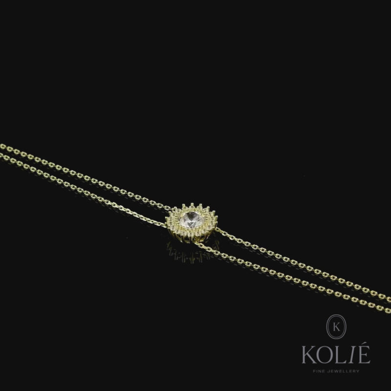 Kolié 9ct yellow gold bracelet featuring a sparkling cubic zirconia centerpiece set within a halo of accent stones, showcased on a sleek gold chain.