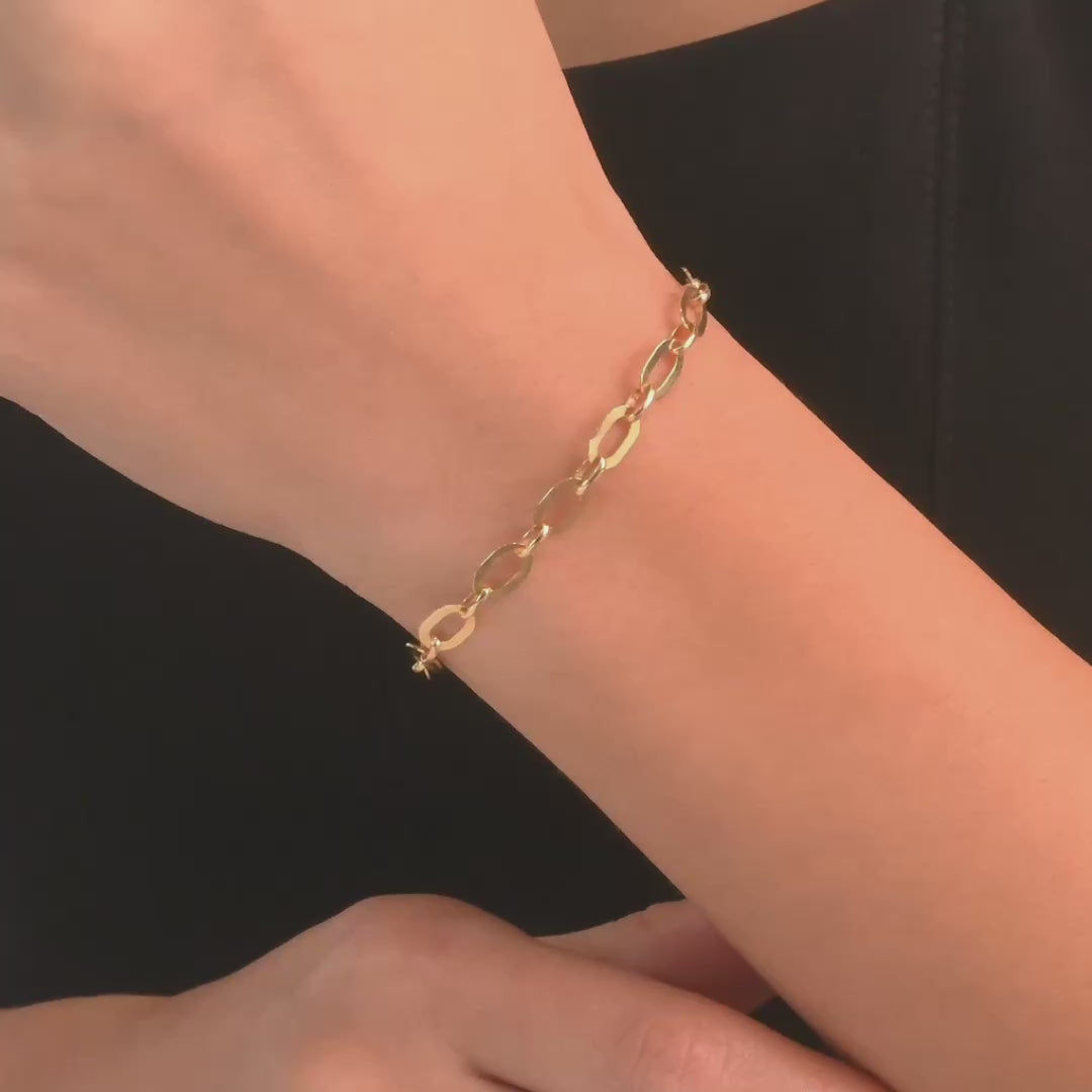 Woman wearing the 14ct gold open link bracelet, showcasing its bold and modern style.