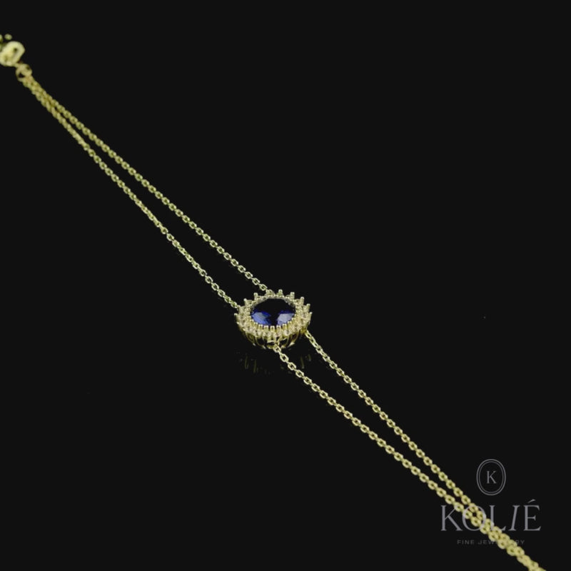 Elegant Kolié 9ct yellow gold bracelet with central cubic zirconia in a deep blue hue, crafted with a delicate gold chain design