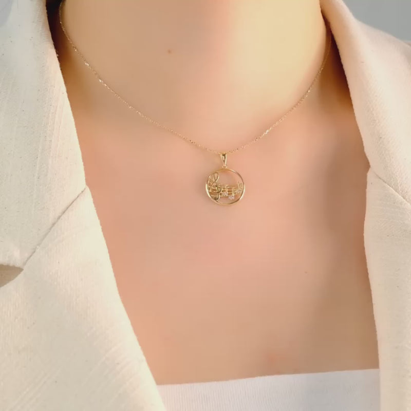 Front view of the pendant highlighting the intricate treble clef design, worn by a model