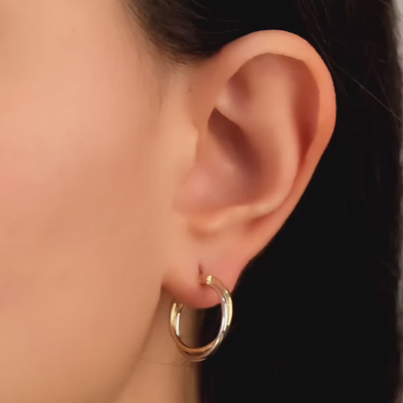 Video of two-tone 14k yellow and white gold hoop earrings on woman's ear.