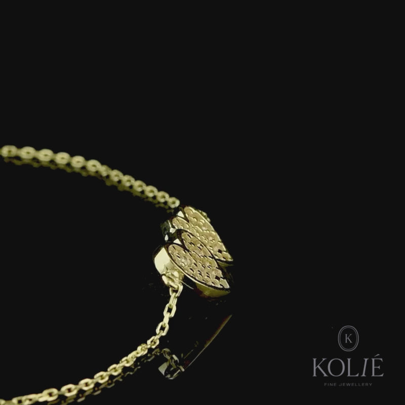 Elegant 9ct yellow gold double heart bracelet by Kolié, featuring two intertwined hearts adorned with sparkling stones, showcased on a black background. Find this exquisite piece at www.kolie.co.uk