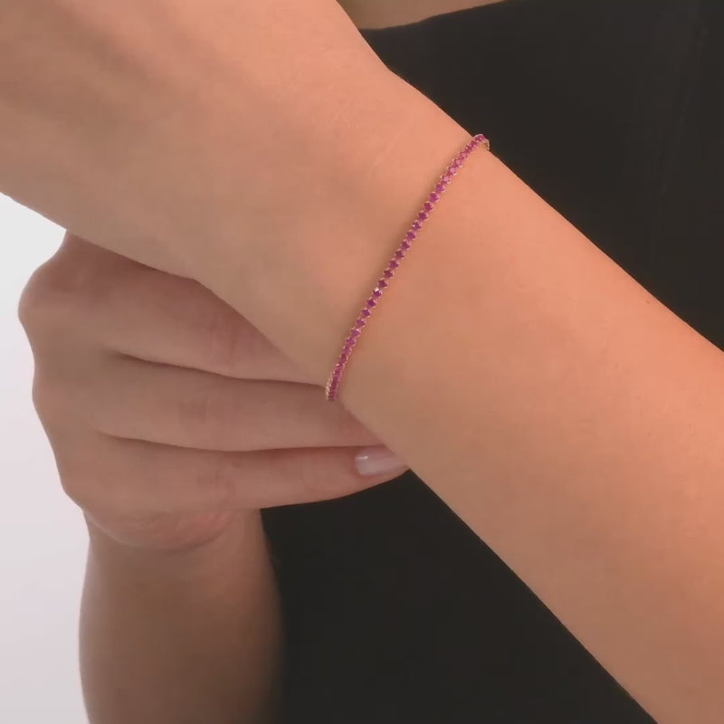 Woman wearing the 14ct gold bracelet with pink cubic zirconia, showcasing its bold and elegant design.