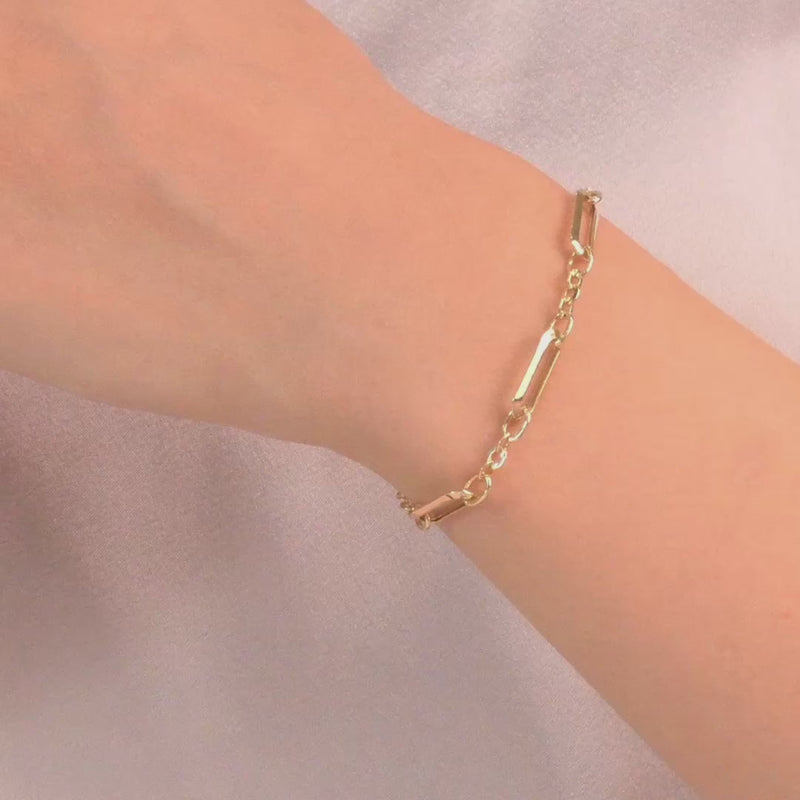 The bracelet worn on a woman's wrist, highlighting its delicate and modern design.